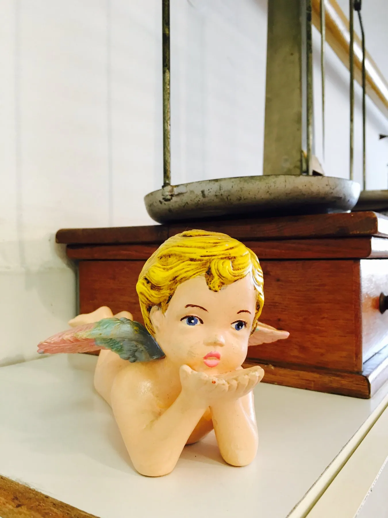 The little angel in front of the old pharmacy scales